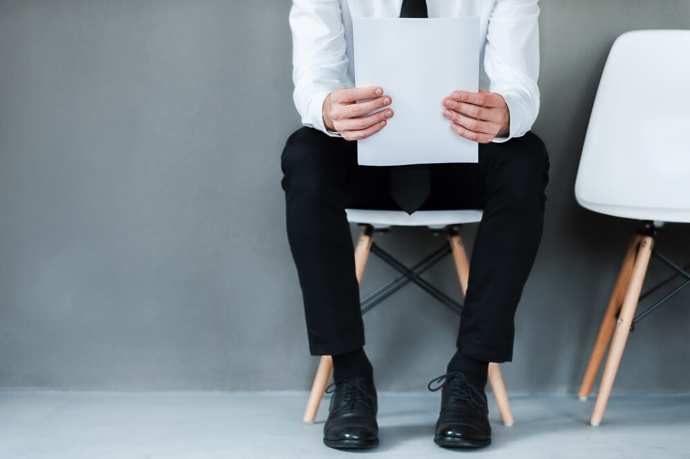 Сидеть на 2 стульях. Человек на стуле Ровно. Сидит в бумагах. While sitting on Chair. Holding Chair on hand.