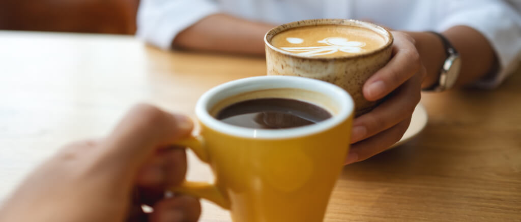 young couple holding and drinking coffee