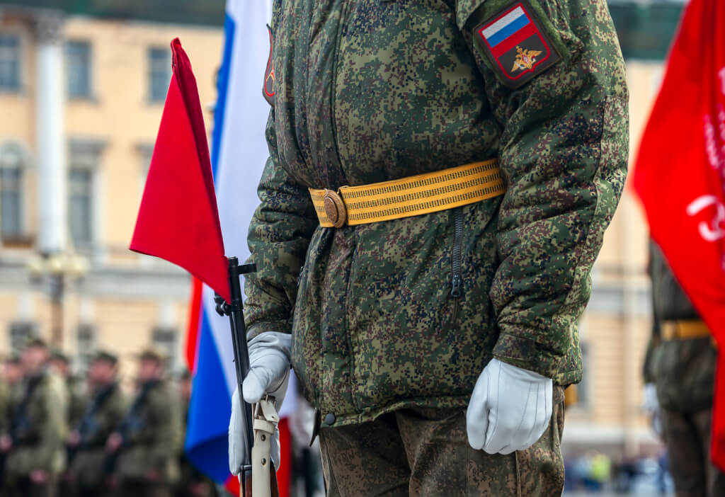 Field military uniform of Russian soldier at parade rehearsal against the background of the colors of the national flag