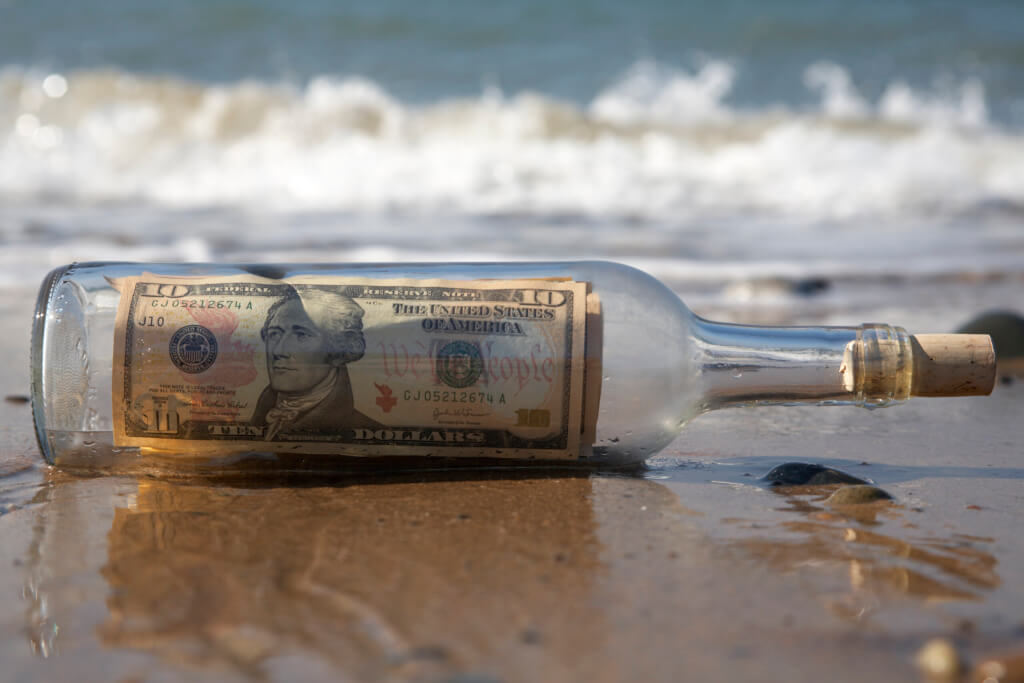 Send or transfer money - message in bottle on beach