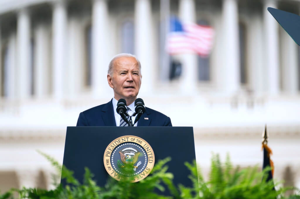 Joe Biden standing outside the White House delivering a speech behind a podium - blurry background for copy-space